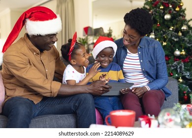 African american family siting on the sofa and using tablet. Christmas, family time and celebration concept using technology. - Powered by Shutterstock