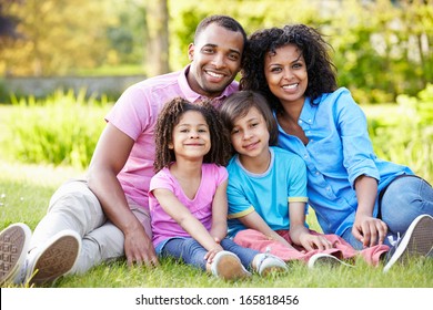 African American Family Sitting In Garden