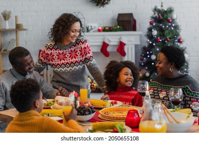 African American Family Smiling During Christmas Dinner At Home