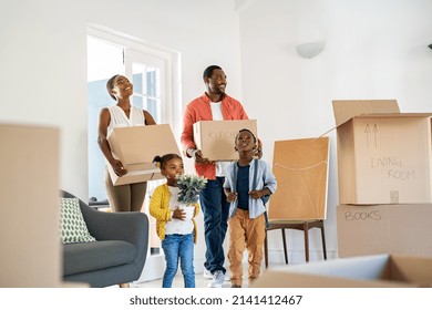 African american family with two children carrying boxes in a new home. Cheerful mature mother and mid adult father holding boxes while entering new house with son and daughter with copy space. - Powered by Shutterstock