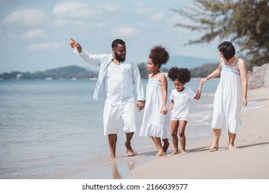African American family walking together on the beach on holiday, having fun on a tropical beach