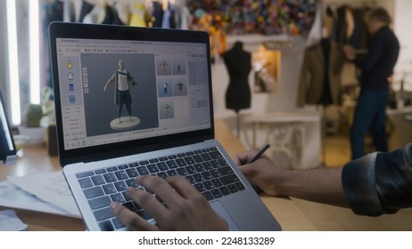 African American fashion designer creates clothes in 3D modeling software on laptop using digital tablet and stylus. He works in atelier workshop. Concept of fashion and technologies in business. - Powered by Shutterstock