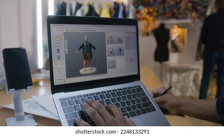 African American fashion designer creates clothes in 3D modeling software on laptop using digital tablet and stylus. He works in atelier workshop. Concept of fashion and technologies in business. - Powered by Shutterstock