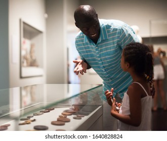 African American Father And Daughter Looking At Stands With Exhibits At Historical Museum 