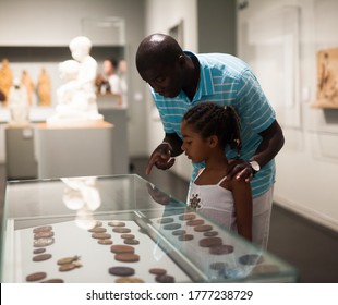 African American Father And Daughter Looking At Stands With Exhibits At Historical Museum 