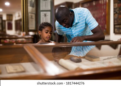 African American Father And Daughter Looking At Stands With Exhibits At Historical Museum