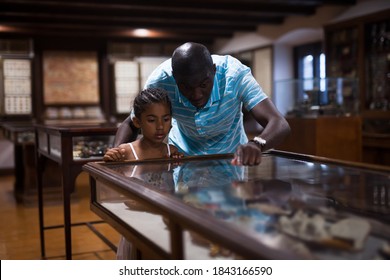 African American Father And Daughter Looking At Stands With Exhibits At Historical Museum