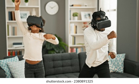African american father and daughter playing video game using virtual reality glasses at home - Powered by Shutterstock