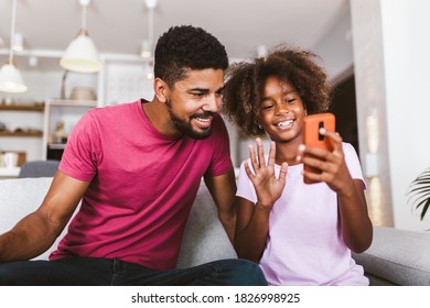 African American Father And Daughter With Smartphone At Home