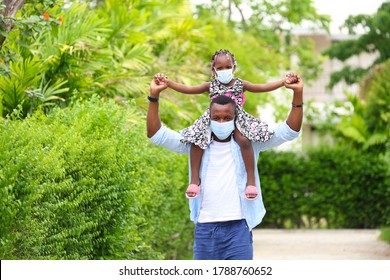 African American Father Gave Piggyback Ride To His Little Daughter And Having A Good Time Together Walking Around The Neighborhood While Wearing Mask During Social Distancing And New Normal For Covid