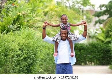 African American Father Gave Piggyback Ride To His Little Daughter With Happy Mental Health And Having A Good Time Together While Walking Outside The House Around The Neighborhood