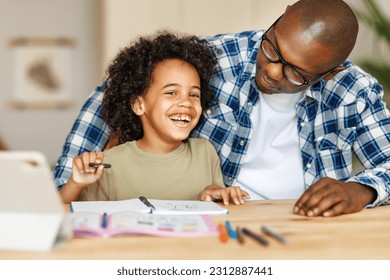 African american father helps son to do homework at home - Powered by Shutterstock