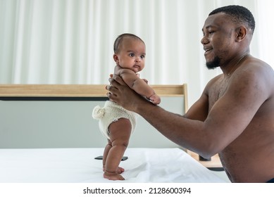 African American Father Holding His 3-month-old Daughter, To Stand In White Bed, To Relationship African American Family And Baby Newborn Concept.