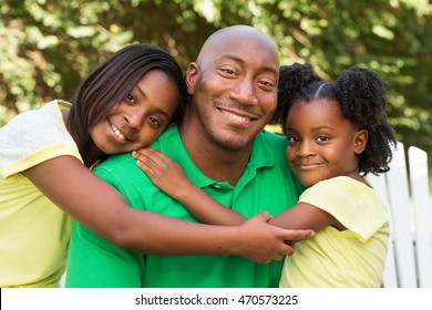 African American Father Hugging His Daughters
