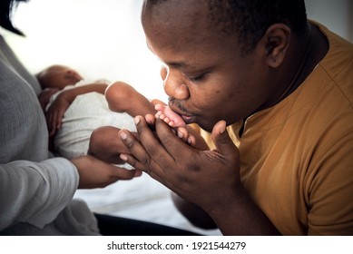 An African American Father Kissing Foot, His 12-day-old Baby Newborn Which Mother Was Holding  With Love And Happy, Concept To African American Family And Newborn