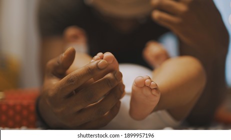 African American Father Playing With Baby Feet. Close Up . High Quality Photo