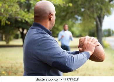 African American Father Playing 
Football With His Son.