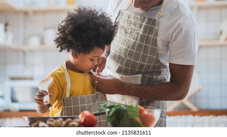 African American Father And Son Cooking In The Kitchen, Helping To Get Dressed, Preparing Food.