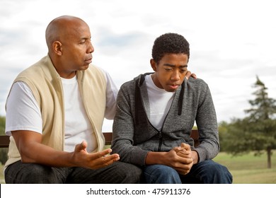 African American father and son in deep conversation.