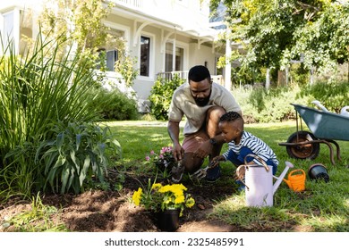 African american father and son digging dirt for planting flowers on field in backyard. Unaltered, lifestyle, gardening, family, love, togetherness, nature, weekend and childhood concept. - Powered by Shutterstock