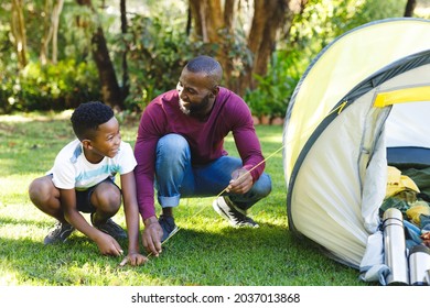 African american father with son having fun pitching tent in garden. family spending time at home. - Powered by Shutterstock