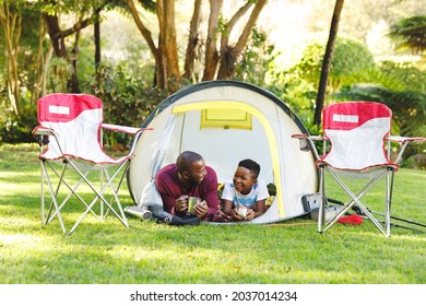 African American Father With Son Having Fun And Lying In Tent In Garden. Family Spending Time At Home.