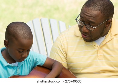 African American Father And Son Talking.