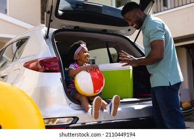 African American Father Talking To Daughter Sitting In The Back Of The Car. Family Trip And Vacation Concept, Unaltered.