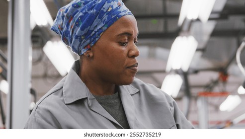 African American female car mechanic working in a township workshop, painting a body of a car in slow motion - Powered by Shutterstock