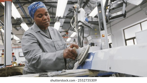 African American female car mechanic working in a township workshop, using a grinder on the side of a car in slow motion - Powered by Shutterstock