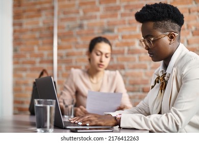 African American Female CEO Working On A Computer While Having Meeting With Job Candidate In The Office. 