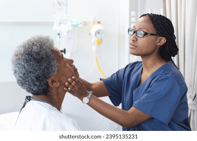 African american female doctor testing eyes of senior female patient in hospital room. Medicine, healthcare and medical services, unaltered. - Powered by Shutterstock