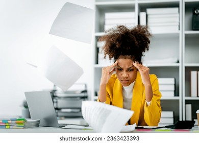 African american female employee stressed while working, paperwork, accounting. Tired businesswoman has a headache at the office. Concept of hard work, stress - Powered by Shutterstock