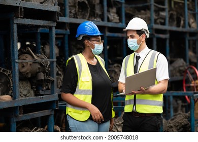 African American Female Employee Worker And Hispanic Man Manager Working Together At Old Auto And Car Parts Warehouse Store. People Wearing Face Mask Prevent Covid-19 Virus