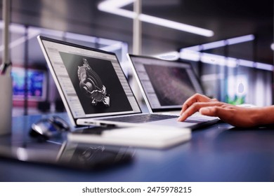 African American Female Engineer Developing Mechanical Parts Using 3D CAD Software on Laptop at Factory Office - Powered by Shutterstock