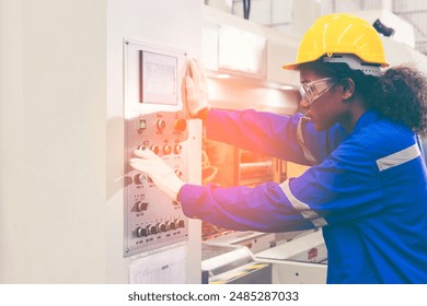 African american female engineer, paper factory worker wearing safety helmet in the automotive part warehouse. Factory workers check and control operate cardboard machines in paper manufacture. - Powered by Shutterstock