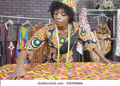 An African American Female Fashion Designer Working On A Pattern Cloth