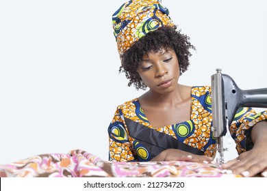 African American Female Fashion Designer Sewing Fabric Over Gray Background