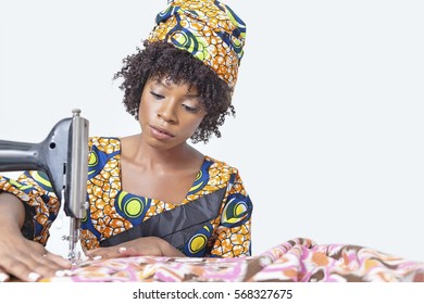 African American Female Fashion Designer Sewing Fabric Over Gray Background