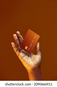 African american female hand holds levitating template Bank credit card with online service on golden orange background - Shutterstock ID 2090666911