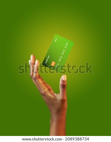 African american female hand and levitating template mockup Bank credit card with online service on green background