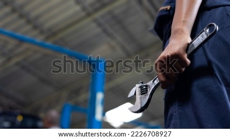 African american female holding tools with wrench. Car maintenance and auto service garage concept. Closeup hand and spanner.