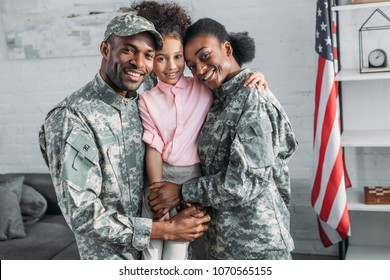 African american female and male soldiers embracing their daughter - Shutterstock ID 1070565155