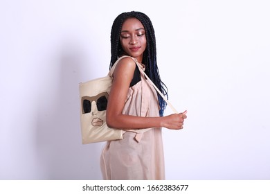 African American Female Model Portrait High Key On White Studio Background Wearing Pink Summer Dress And Holding Cotton Backpack With Handmade Embroidery
