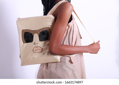 African American Female Model Portrait High Key On White Studio Background Wearing Pink Summer Dress And Holding Cotton Backpack With Handmade Embroidery
