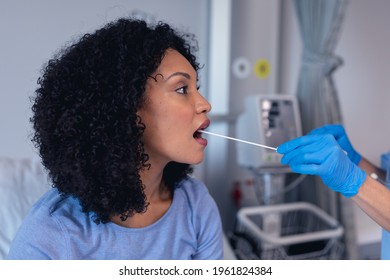 African American Female Patient With Mouth Open Tested With Swab Test. Medical Professional At Work During Coronavirus Covid 19 Pandemic.