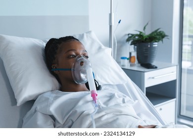 African american female patient with oxygen mask, lying on bed in hospital room. Hospital, medicine and healthcare, unaltered. - Powered by Shutterstock