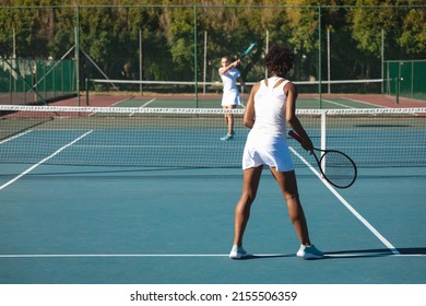 African american female player playing tennis game with young caucasian competitor at court. unaltered, sport, competition and tennis game concept. - Powered by Shutterstock
