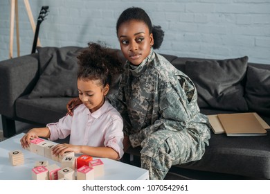 African American Female Soldier With Daughter Playing Words Game