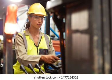 African American female staff driving forklift in warehouse. This is a freight transportation and distribution warehouse. Industrial and industrial workers concept - Powered by Shutterstock